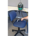 Woman using Bissell BGU1451T bagged upright vacuum to clean a chair.