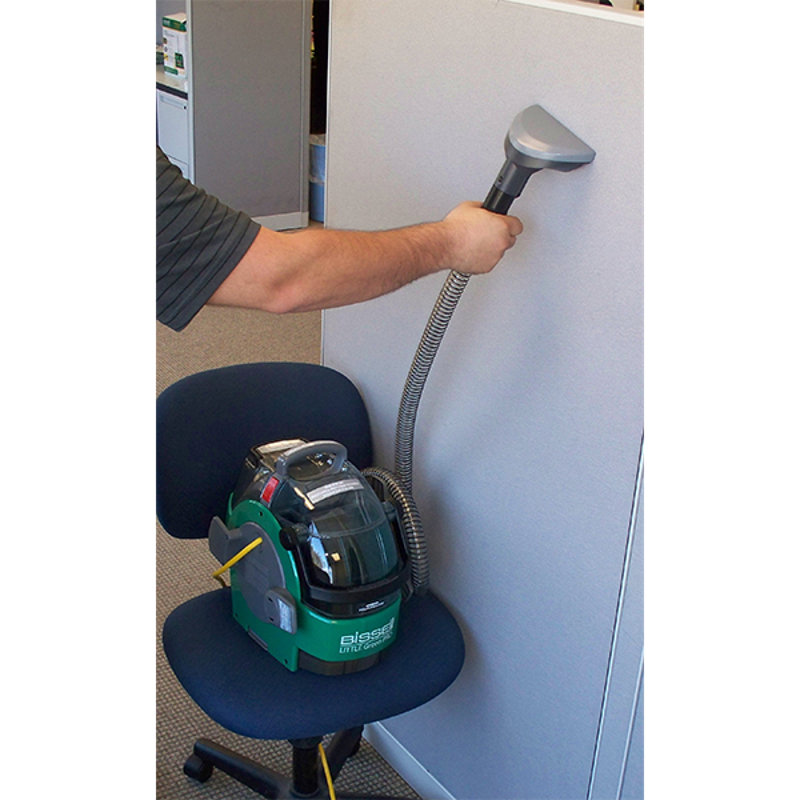 Woman cleaning a wall with Bissell BGU1451T bagged upright vacuum.