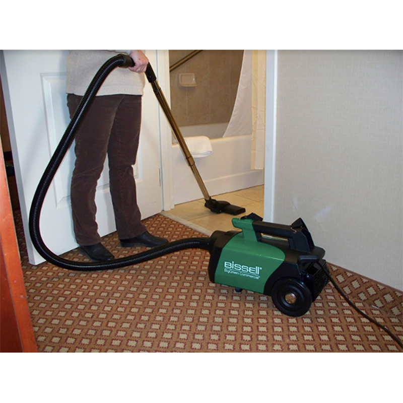 Woman cleaning floor with a vacuum on a hardwood surface, effectively removing dirt and debris.
